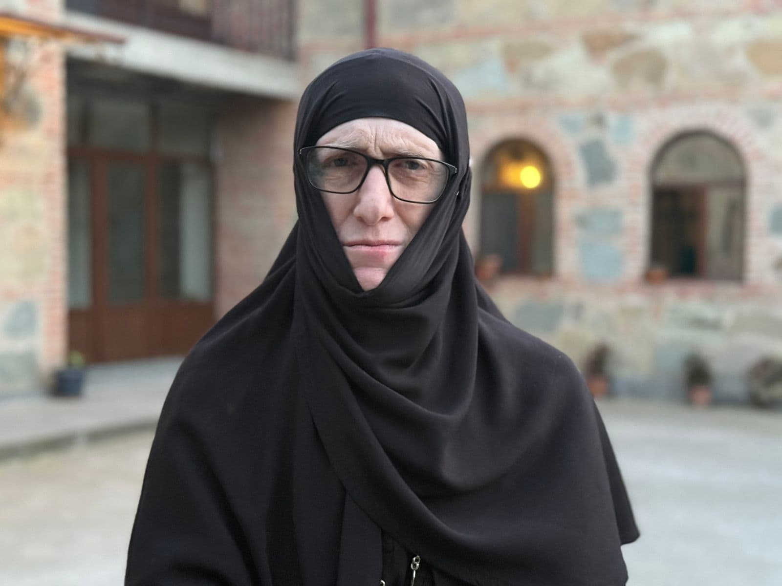 <p style="text-align: justify">დღევანდელი რუბრიკის "ადამიანები ისტორიით“ სტუმარია <strong><em>იღუმენია მარიამი</em></strong> (ჯაფარიძე) - ადამიანი, რომლის ცხოვრება თავისთავად არის გზა, ტკივილითა და სიყვარულით სავსე, შინაგანი ბრძოლიდან სულიერ სიმშვიდემდე.</p><p style="text-align: justify">მისი საერო სახელი ლელა იყო. აქტიური, განათლებული და მოაზროვნე ახალგაზრდა ქალი, რომელმაც საბჭოთა კავშირის ბოლო წლებში მიიღო განათლება ივანე ჯავახიშვილის სახელობის თბილისის სახელმწიფო უნივერსიტეტში, ფილოლოგიის ფაკულტეტზე. ამის შემდეგი პერიოდი ის იყო მორჩილი ელენე და პარალელურად მუშაობდა საპატრიარქოს გამომცემლობაში.</p><p style="text-align: justify">1994 წელს ელენემ მიიღო სამონაზვნო სახელი - ემილია, ხოლო 2000 წელს, ეკლესიური მსახურების მრავალი წლის შემდეგ, ეკურთხა როგორც მონაზონი მარიამი. უკვე 2016 წელს მას მიენიჭა იღუმენიას ხარისხი.</p><p style="text-align: justify">სულიერების გზა და პირადი თავგადასავალი</p><p style="text-align: justify">ვიდეოში იღუმენია მარიამი გულწრფელად და ღრმად საუბრობს იმ გზაზე, რომელიც გაიარა - როგორ დაუბრუნდა ეკლესიას, როგორ იგრძნო შინაგანი მოწოდება, რომ გაჩერებულიყო და ცხოვრება ღმერთისთვის მიეძღვნა.</p><p style="text-align: justify">"საღვთისმსახურო ცხოვრება - ეს არის მუდმივი ყოფნა ჭეშმარიტებასთან", - ამბობს დედაო.</p><p style="text-align: justify"><strong>ეროვნული მოძრაობის დღეები და გადამწყვეტი მომენტი</strong></p><p style="text-align: justify">დედა მარიამი ასევე იხსენებს 1980–90-იანი წლების ეროვნულ მოძრაობაში მონაწილეობას. ის ჰყვება იმ შიგნით გამანადგურებელ, მაგრამ საბოლოოდ განმანათლებელ მომენტზე, როცა გადაწყვიტა, რომ ბრძოლა ქუჩაში აღარ იყო მისი გზა და რომ სულიერი ბრძოლა იყო ის, რასაც უნდა შესწიროს თავი.</p><p style="text-align: justify"><strong>გზის განმსაზღვრელი ადამიანები და იდეები</strong></p><p style="text-align: justify">აღსანიშნავია მისი საუბარი უწმინდესის ილია II-ის როლზე მის ცხოვრებაში. იგი უდიდეს მადლიერებას გამოხატავს და ამბობს, რომ მისგან უსაზღვრო სითბო და სიბრძნე მიიღო.</p><p style="text-align: justify">დედა მარიამი საუბრობს მერაბ მამარდაშვილის, ჰერმან ჰესეს და სხვა მოაზროვნეების გავლენაზეც - ადამიანებზე და ტექსტებზე, რომლებმაც მის სულიერ ჩამოყალიბებას ხელი შეუწყვეს.</p><p style="text-align: justify"><strong>რას ნიშნავს ევროპა დედა მარიამისთვის</strong></p><p style="text-align: justify">ევროპული ხელოვნება, მწერლობა, ფილოსოფია მისთვის არის სამყარო, რომელშიც ის გაიზარდა ჩამოყალიბდა პიროვნულად და მოემზადა მისი მთავარი გადაწყვეტილებისთვის.</p><p style="text-align: justify"><strong>დღევანდელობა და საზოგადოება: მორალური დილემები და პოლარიზაცია</strong></p><p style="text-align: justify">"პოლარიზაციამ შეიძლება ადამიანი ფსიქიკურ სიღატაკემდე მიიყვანოს", - ამბობს იღუმენია მარიამი.</p><p style="text-align: justify">მისი შეფასებით, თანამედროვე საზოგადოება ხშირად ივიწყებს იმას, რომ ცხოვრების ყოველი წამი ძვირფასია და ის არ უნდა დაიხარჯოს შუღლსა და დაპირისპირებაში.</p><p style="text-align: justify">"ადამიანის სიცოცხლე არ უნდა დაიხარჯოს, არც ერთი წამი არ უნდა დაიხარჯოს ადამიანის ცხოვრების რაღაცასთან დაპირისპირებაში" - ამბობს დედა მარიამი.</p><div class="iframe-wrapper"><iframe src="https://www.youtube.com/embed/wOeHqQqbzhs?si=SzaBhGoEWjARbAvi" frameborder="0" allowfullscreen="true" width="560" height="315" title="YouTube video player" allow="accelerometer; autoplay; clipboard-write; encrypted-media; gyroscope; picture-in-picture; web-share"></iframe></div>